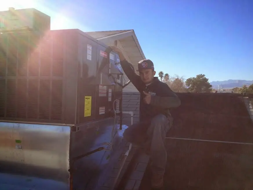 HVAC technician performing AC Tune-Up on a rooftop unit in South Bradenton